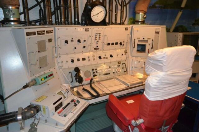a control room with a clock and other equipment