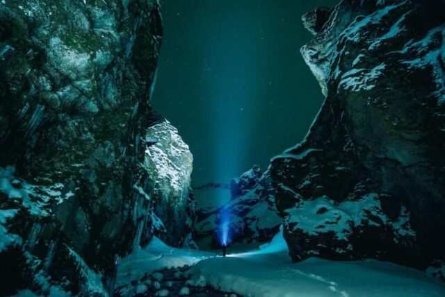 person standing surrounded by snowy mountain