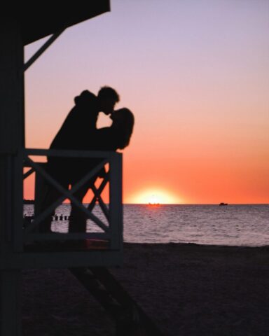 Photo by Cocodillaa.com a silhouette of a couple of people sitting on a bench looking at the sunset
