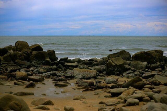 a rocky beach with water in the background