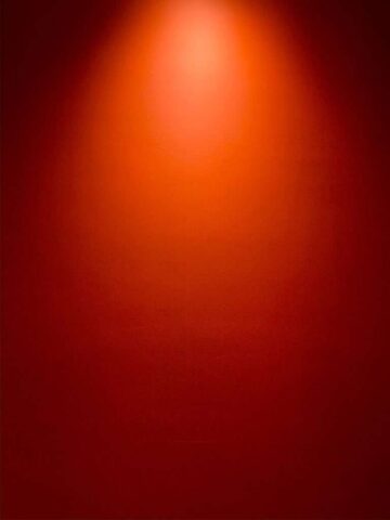 a red wall with a light on top of it