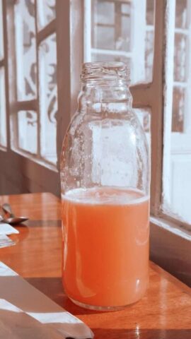 Photo by Cocodillaa.com A refreshing glass bottle of juice on a table by a window in Bogota, Colombia.