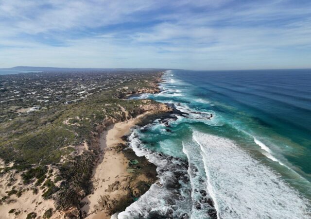 Ocean waves crash against the scenic coastline.