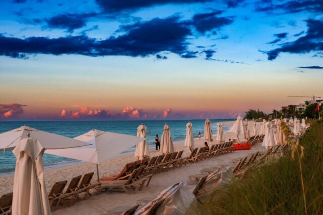 A row of beach chairs sitting on top of a sandy beach