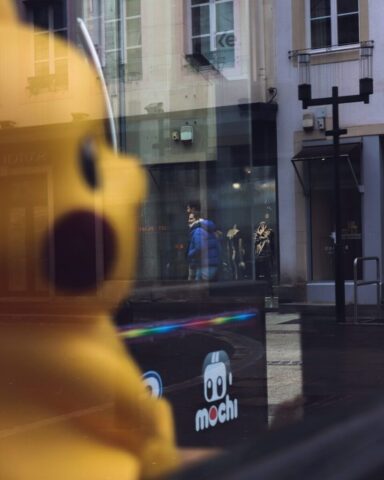 Photo by Cocodillaa.com A large yellow stuffed animal sitting in front of a store window