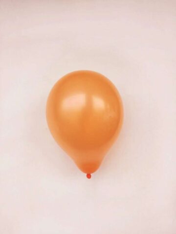 Photo by Cocodillaa.com orange balloon on white surface