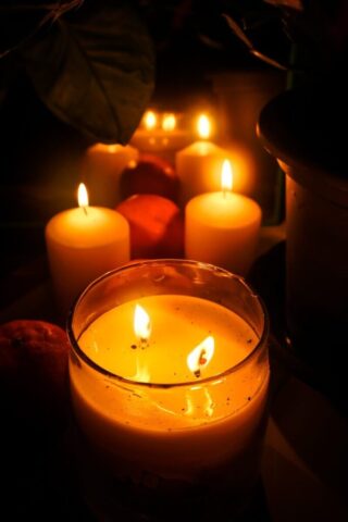 Photo by Cocodillaa.com Several lit candles glowing in the dark.