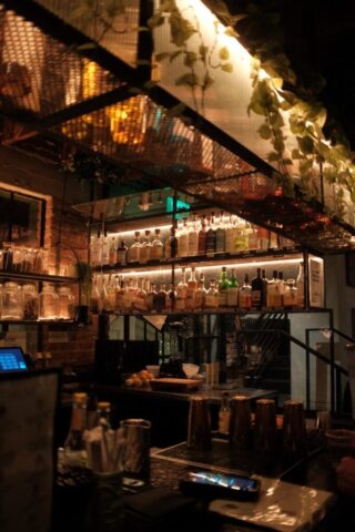 A dimly lit bar with a well-stocked shelf.