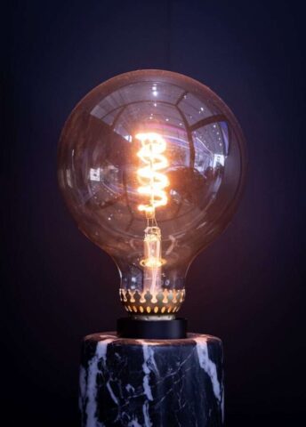 Photo by Cocodillaa.com a light bulb sitting on top of a marble base