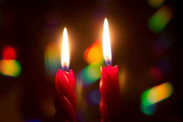 Photo by Cocodillaa.com Two red candles are lit in the dark