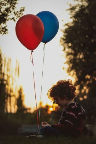 Photo by Cocodillaa.com girl in blue and white stripe shirt holding balloons during daytime