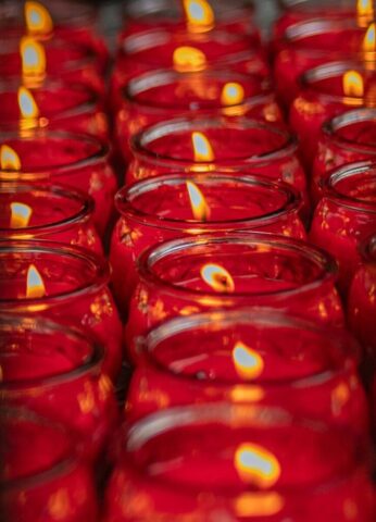 Photo by Cocodillaa.com rows of red glass jars with lit candles in them