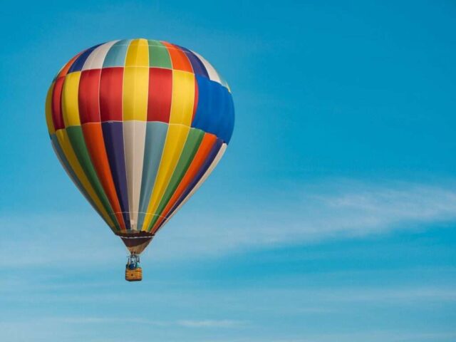 Photo by Cocodillaa.com panning photography of flying blue, yellow, and red hot air balloon