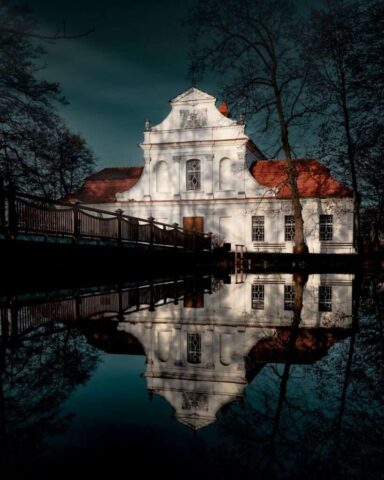 a large white building sitting next to a body of water