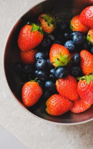 A bowl filled with fresh strawberries and blueberries.