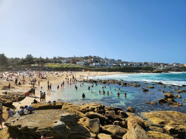 a crowded beach with lots of people on it