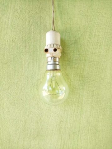 Photo by Cocodillaa.com clear glass light bulb on green textile