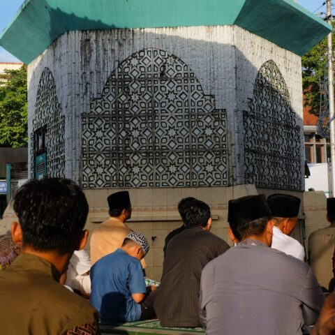 Photo by Cocodillaa.com a group of people sitting on a bench in front of a building