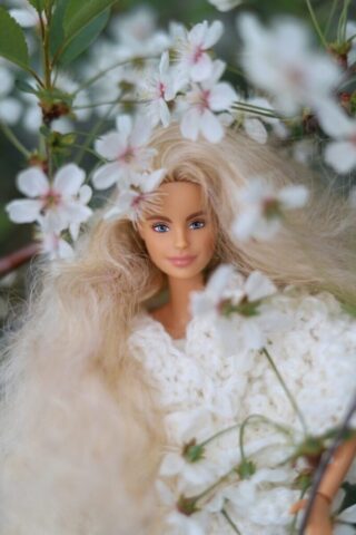 Barbie doll surrounded by beautiful white flowers.