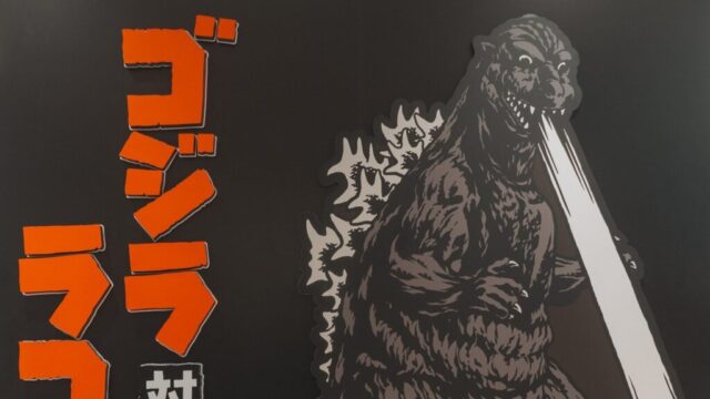 Photo by cocodillaa.com Godzilla breathes atomic fire against a dark background.