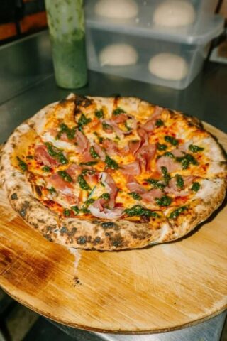 Photo by Cocodillaa.com a pizza sitting on top of a wooden cutting board