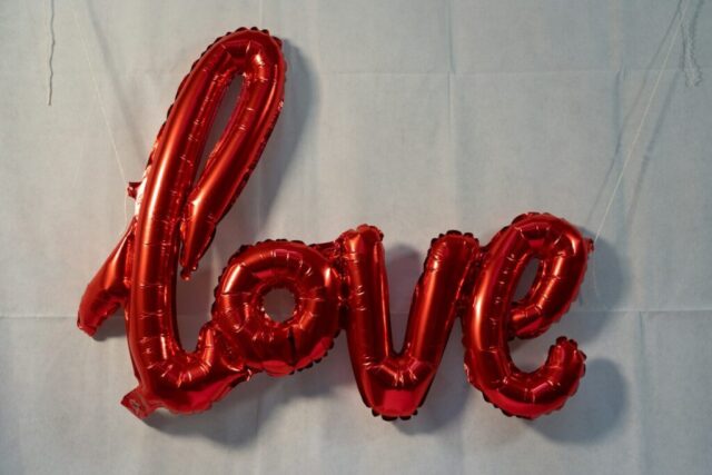 Photo by Cocodillaa.com a red balloon spelling love on a white background