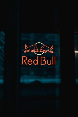 a red bull sign is lit up in the dark