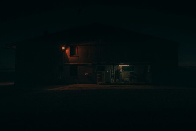 a dark house with a light on at night