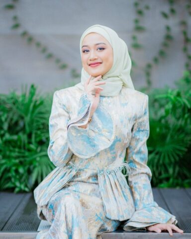 Photo by Cocodillaa.com a woman wearing a hijab sitting on a bench