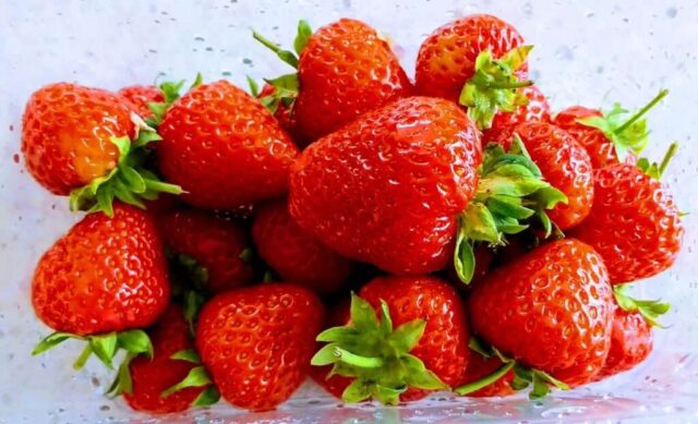 a pile of strawberries sitting on top of a table
