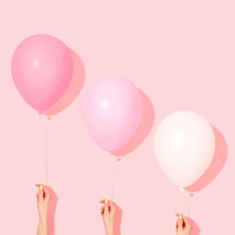 Photo by Cocodillaa.com person holding pink and white balloon