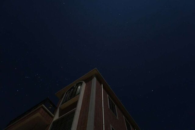a tall building with a sky full of stars in the background