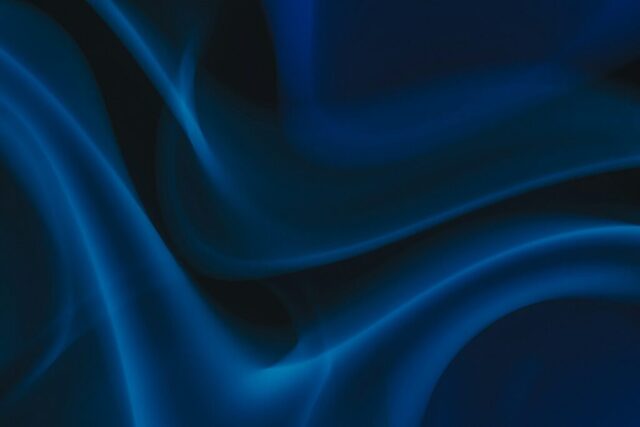 Photo by Cocodillaa.com a blue and black background with wavy lines