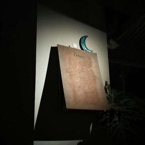 A wooden sign with a crescent moon decoration