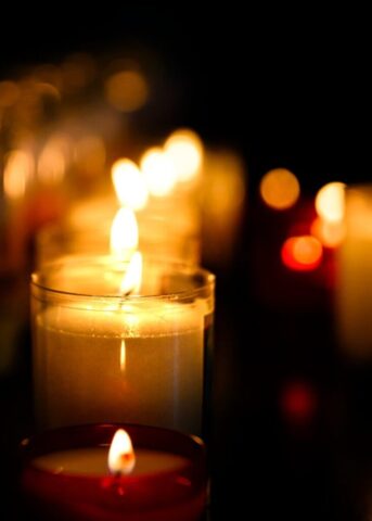 Photo by Cocodillaa.com Several lit candles glowing in the dark.