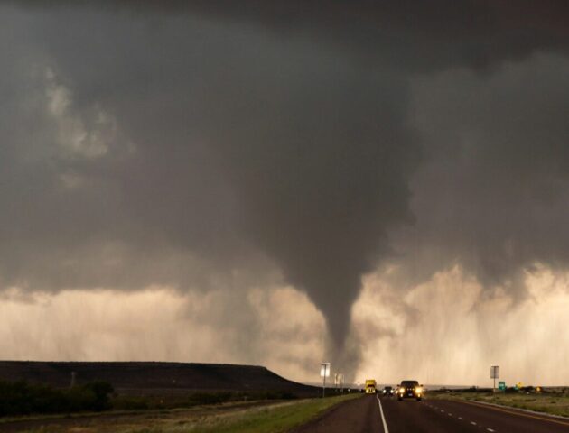 a large storm cloud looms over a highway