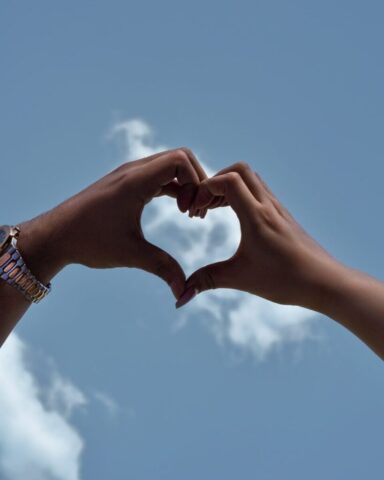 Photo by Cocodillaa.com two hands making a heart shape against a blue sky