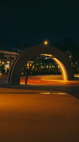 Illuminated archway over a colorful path at night