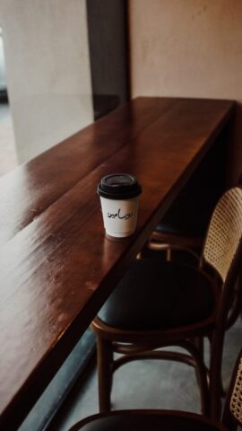 a cup of coffee sitting on top of a wooden table