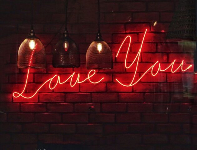 Photo by Cocodillaa.com three pendant lamps with love you neon sign on brick wall