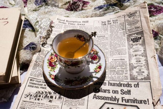 a cup of tea sitting on top of a newspaper
