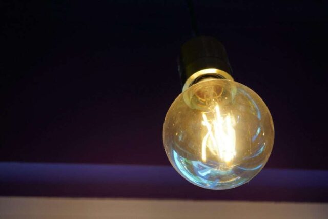 Photo by Cocodillaa.com A light bulb hanging from a ceiling in a dark room