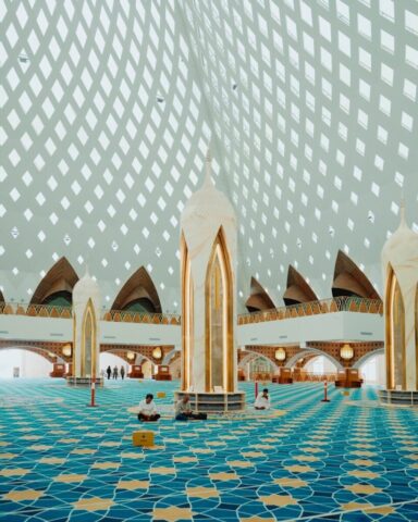 Photo by Cocodillaa.com Interior of a modern mosque with patterned carpet and ceiling
