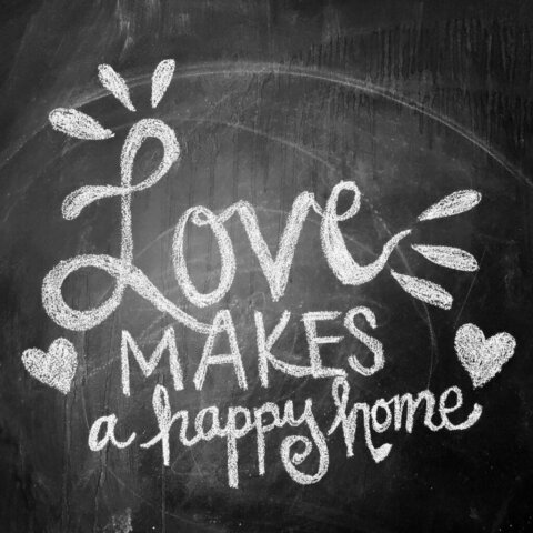 Chalkboard art with 'Love makes a happy home' message, ideal for home decor themes.