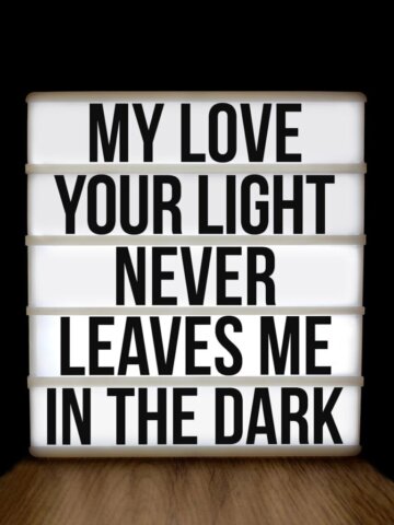 Lightbox displays motivational message about love and light against a dark background.