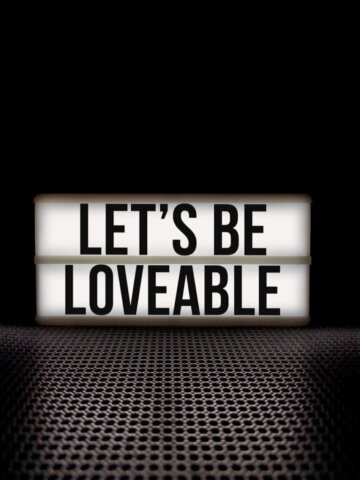 Motivational message 'Let's Be Loveable' displayed on a lightbox with a black background.