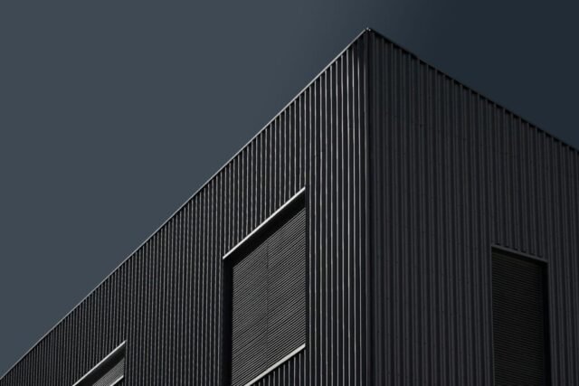 a black building with a clock on the side of it