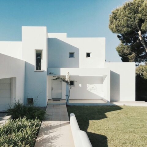 photo by Cocodillaa.com white concrete house near green tree during daytime