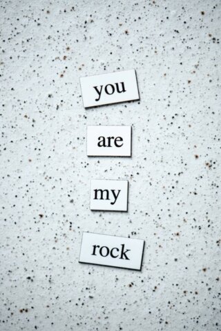 Inspirational words 'you are my rock' on a textured background, ideal for motivation.
