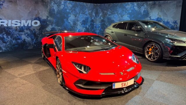 Two lamborghinis are showcased in a showroom.